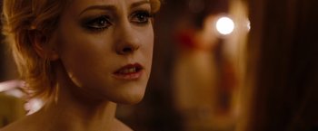 Movie still from “Sucker Punch” (2011), directed by Zack Snyder – A woman's face in a dimly - lit room; Close Up shot, Over the shoulder angle