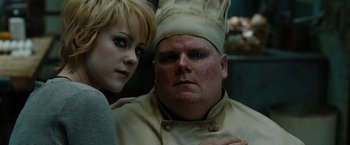 Movie still from “Sucker Punch” (2011), directed by Zack Snyder – A woman standing next to a man wearing a chef's hat; Close Up shot, Over the shoulder angle