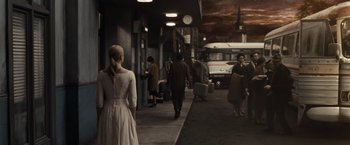 Movie still from “Sucker Punch” (2011), directed by Zack Snyder – A woman in a white dress walking down a street; Wide shot, High angle