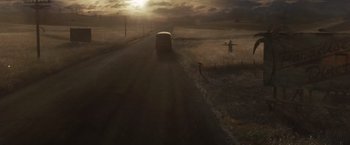 Movie still from “Sucker Punch” (2011), directed by Zack Snyder – A bus driving down a road near a field; Extreme Wide shot, High angle