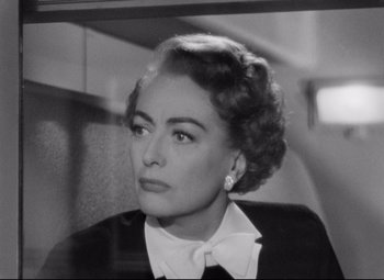 Movie still from “Sudden Fear” (1952), directed by David Miller – An old photo of an older woman in a black suit; Close Up shot, Over the shoulder angle