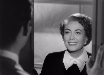 Movie still from “Sudden Fear” (1952), directed by David Miller – An old photo of a woman smiling in front of a mirror; Close Up shot, Over the shoulder angle