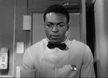 Movie still from “Sudden Fear” (1952), directed by David Miller – A black and white photo of a man wearing a bow tie; Close Up shot, Low angle