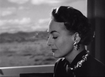 Movie still from “Sudden Fear” (1952), directed by David Miller – An old photo of a woman looking out a window; Close Up shot, Low angle