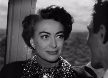 Movie still from “Sudden Fear” (1952), directed by David Miller – An old black and white photo of a woman; Close Up shot, Over the shoulder angle