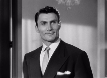 Movie still from “Sudden Fear” (1952), directed by David Miller – Black and white photograph of a man in a suit and tie; Close Up shot, Low angle