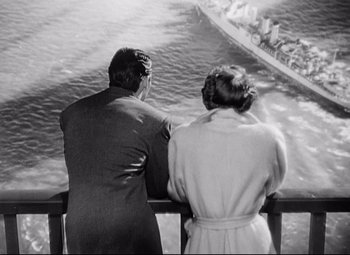 Movie still from “Sudden Fear” (1952), directed by David Miller – A man and a woman looking out over the water; Wide shot, High angle