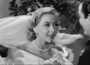 Movie still from “Sudden Fear” (1952), directed by David Miller – A black - and - white photo of a woman in a white dress; Close Up shot, Low angle
