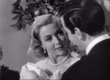 Movie still from “Sudden Fear” (1952), directed by David Miller – A man and a woman in formal wear looking at one another; Close Up shot, Over the shoulder angle