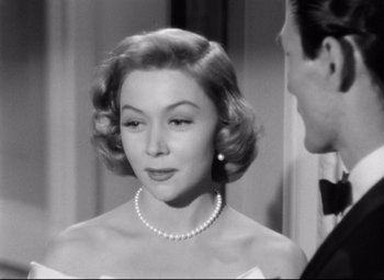 Movie still from “Sudden Fear” (1952), directed by David Miller – A black and white photo of a woman in a white dress; Close Up shot, Over the shoulder angle