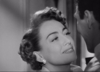 Movie still from “Sudden Fear” (1952), directed by David Miller – An old photo of a woman smiling with her eyes closed; Close Up shot, Over the shoulder angle