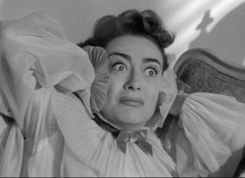 Movie still from “Sudden Fear” (1952), directed by David Miller – An old black and white photo of a woman with a surprised look on her face; Close Up shot, Low angle