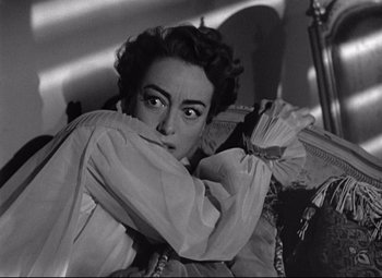 Movie still from “Sudden Fear” (1952), directed by David Miller – An old black and white photo of a woman leaning on a pillow; Close Up shot, Over the shoulder angle