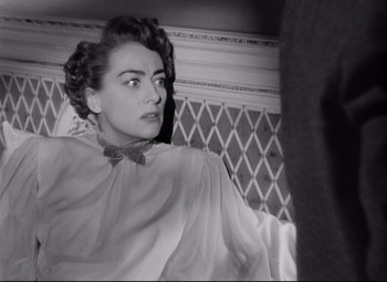 Movie still from “Sudden Fear” (1952), directed by David Miller – An old black and white photo of a woman looking at the camera; Close Up shot, High angle