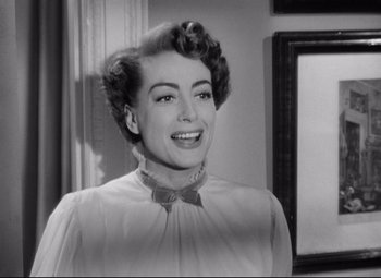 Movie still from “Sudden Fear” (1952), directed by David Miller – An old photo of a woman smiling for the camera; Close Up shot, Low angle