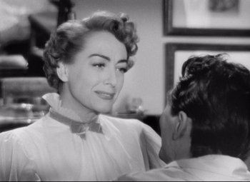 Movie still from “Sudden Fear” (1952), directed by David Miller – An old photo of a woman in a white dress; Close Up shot, Over the shoulder angle