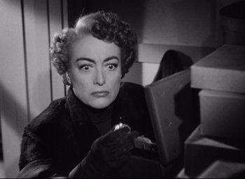 Movie still from “Sudden Fear” (1952), directed by David Miller – An old photo of a woman with a pen in her hand; Close Up shot, Low angle