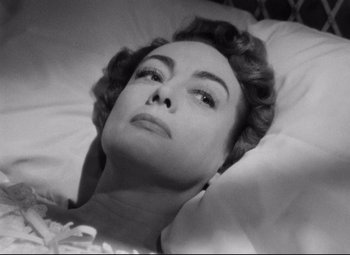 Movie still from “Sudden Fear” (1952), directed by David Miller – A woman laying in a bed looking up at the sky; Close Up shot, High angle