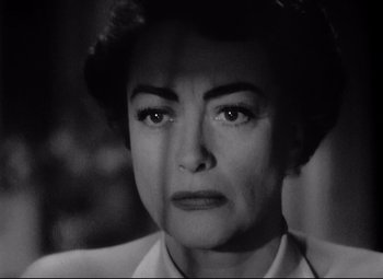 Movie still from “Sudden Fear” (1952), directed by David Miller – An older woman with short dark hair is looking at the camera; Close Up shot, Low angle