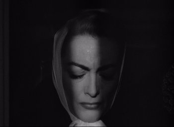 Movie still from “Sudden Fear” (1952), directed by David Miller – A black and white photo of a woman with a veil over her head; Close Up shot, Overhead angle