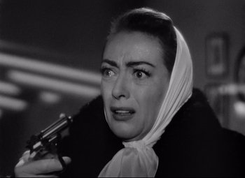 Movie still from “Sudden Fear” (1952), directed by David Miller – An old photo of a woman holding a gun in her hand; Close Up shot, Low angle