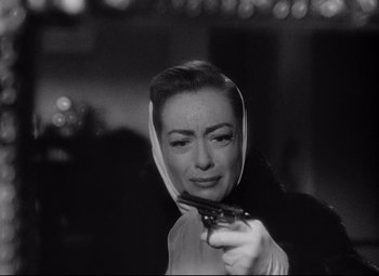 Movie still from “Sudden Fear” (1952), directed by David Miller – A black and white photo of a woman holding a mirror; Close Up shot, Over the shoulder angle