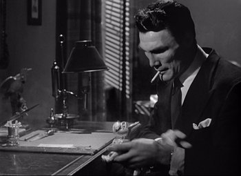 Movie still from “Sudden Fear” (1952), directed by David Miller – A black and white photo of a man smoking a cigarette; Close Up shot, Low angle