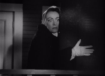 Movie still from “Sudden Fear” (1952), directed by David Miller – An old photo of a woman looking out of a window; Medium shot, Low angle