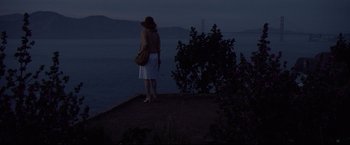 Movie still from “Sudden Impact” (1983), directed by Clint Eastwood – A woman standing on the edge of a pier at night; Wide shot, High angle