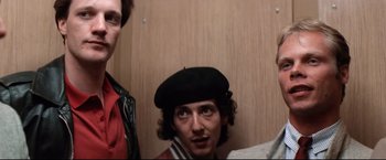 Movie still from “Sudden Impact” (1983), directed by Clint Eastwood – A man in a black hat and a man in a red jacket; Close Up shot, Low angle