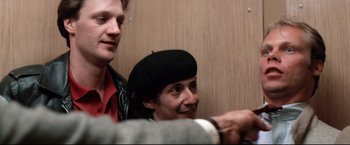 Movie still from “Sudden Impact” (1983), directed by Clint Eastwood – A man and a woman wearing hats and smiling for the camera; Close Up shot, Low angle