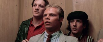 Movie still from “Sudden Impact” (1983), directed by Clint Eastwood – A man in a suit standing next to two other men; Close Up shot, Low angle