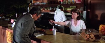 Movie still from “Sudden Impact” (1983), directed by Clint Eastwood – A man and a woman at a table in a restaurant; Medium shot, Over the shoulder angle