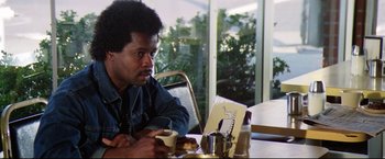 Movie still from “Sudden Impact” (1983), directed by Clint Eastwood – A man sitting at a table with a cup of coffee; Close Up shot, Over the shoulder angle