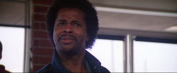 Movie still from “Sudden Impact” (1983), directed by Clint Eastwood – A person with curly hair and a beard; Close Up shot, Low angle