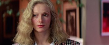 Movie still from “Sudden Impact” (1983), directed by Clint Eastwood – A person with long blonde hair; Close Up shot, Over the shoulder angle