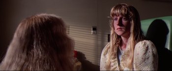 Movie still from “Sudden Impact” (1983), directed by Clint Eastwood – A woman with long blonde hair is looking into a mirror; Close Up shot, Over the shoulder angle