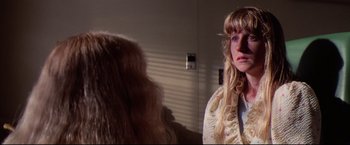 Movie still from “Sudden Impact” (1983), directed by Clint Eastwood – A woman with long blonde hair is looking at another woman with long blonde hair; Close Up shot, Over the shoulder angle