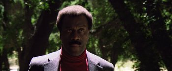 Movie still from “Sudden Impact” (1983), directed by Clint Eastwood – A man in a red shirt and black jacket; Close Up shot, Low angle