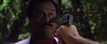 Movie still from “Sudden Impact” (1983), directed by Clint Eastwood – A man holding a pair of scissors up to his face; Extreme Close Up shot, High angle