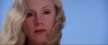 Movie still from “Sudden Impact” (1983), directed by Clint Eastwood – A woman's face with a blue sky background; Close Up shot, Low angle