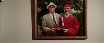 Movie still from “Sudden Impact” (1983), directed by Clint Eastwood – An older man and a young man in a graduation cap and gown; Close Up shot, Low angle