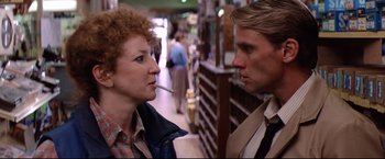 Movie still from “Sudden Impact” (1983), directed by Clint Eastwood – A man and a woman are standing in a store; Close Up shot, Low angle