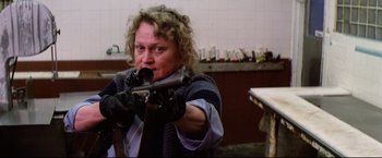 Movie still from “Sudden Impact” (1983), directed by Clint Eastwood – A woman is holding a rifle in her hands; Medium shot, Low angle