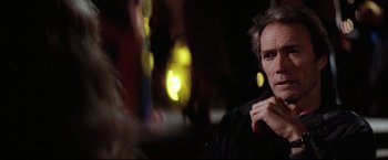Movie still from “Sudden Impact” (1983), directed by Clint Eastwood – A man in a black shirt is looking at the camera; Close Up shot, Over the shoulder angle