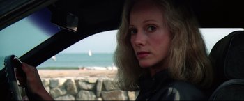 Movie still from “Sudden Impact” (1983), directed by Clint Eastwood – A woman in a car looking out the window at the ocean; Close Up shot, Low angle