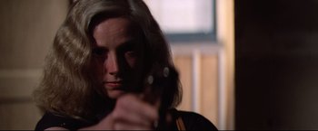 Movie still from “Sudden Impact” (1983), directed by Clint Eastwood – A woman holding a gun in her hand; Close Up shot, Low angle