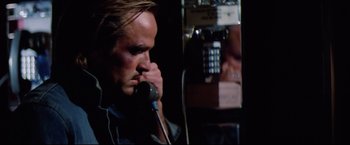 Movie still from “Sudden Impact” (1983), directed by Clint Eastwood – A man talking on a phone while sitting in a chair; Close Up shot, Low angle