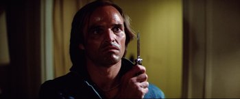Movie still from “Sudden Impact” (1983), directed by Clint Eastwood – A person holding a pair of knifes; Close Up shot, Low angle