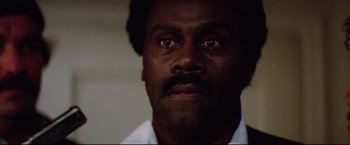 Movie still from “Sudden Impact” (1983), directed by Clint Eastwood – A person wearing a white shirt; Close Up shot, Low angle